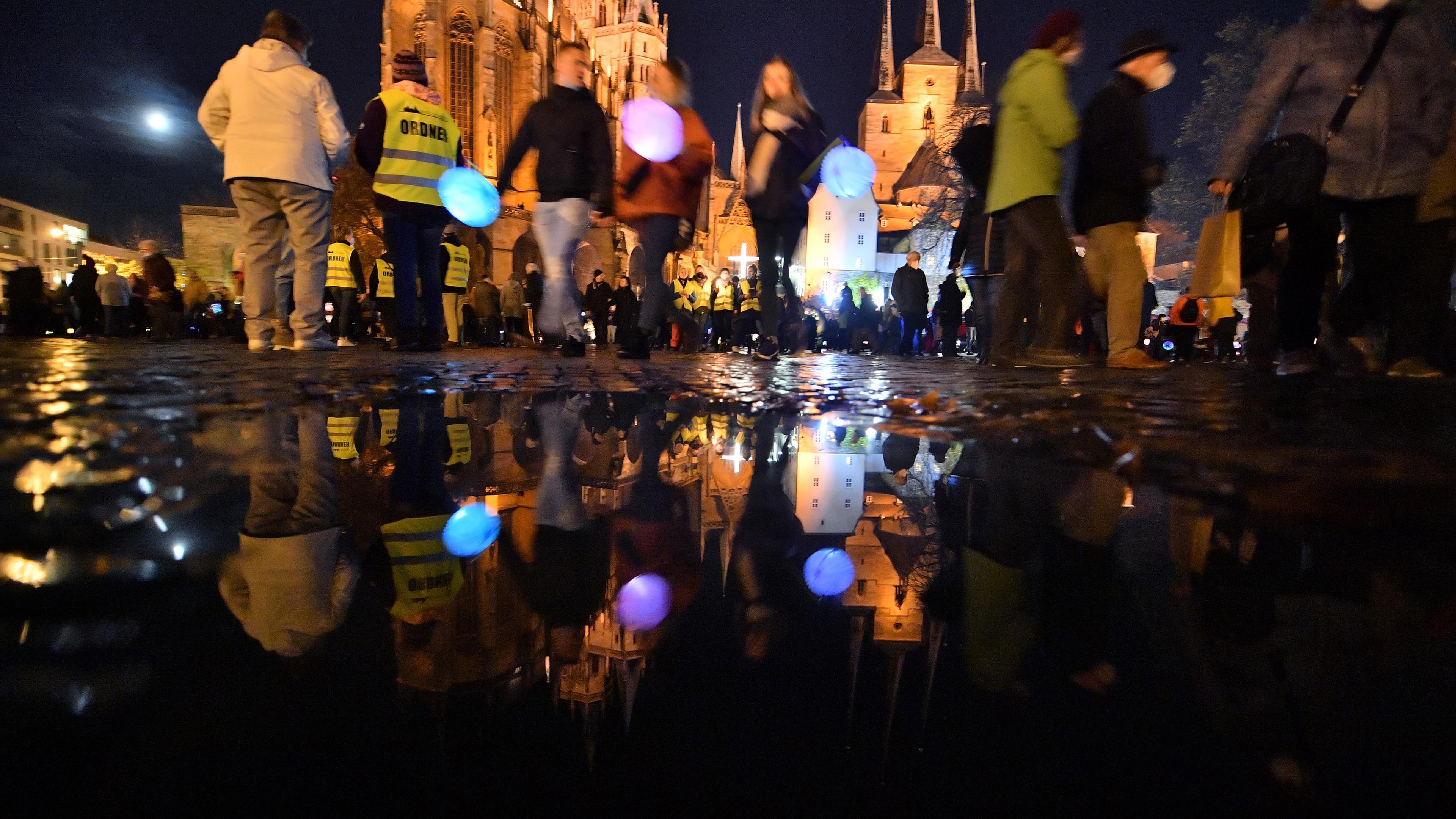 Kinder gehen in der Dämmerung mit Laternen spazieren, vorneweg reitet jemand als St. Martin verkleidet.