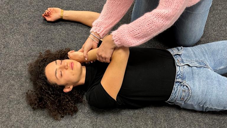 Arm der verletzten Person wird gekreuzt