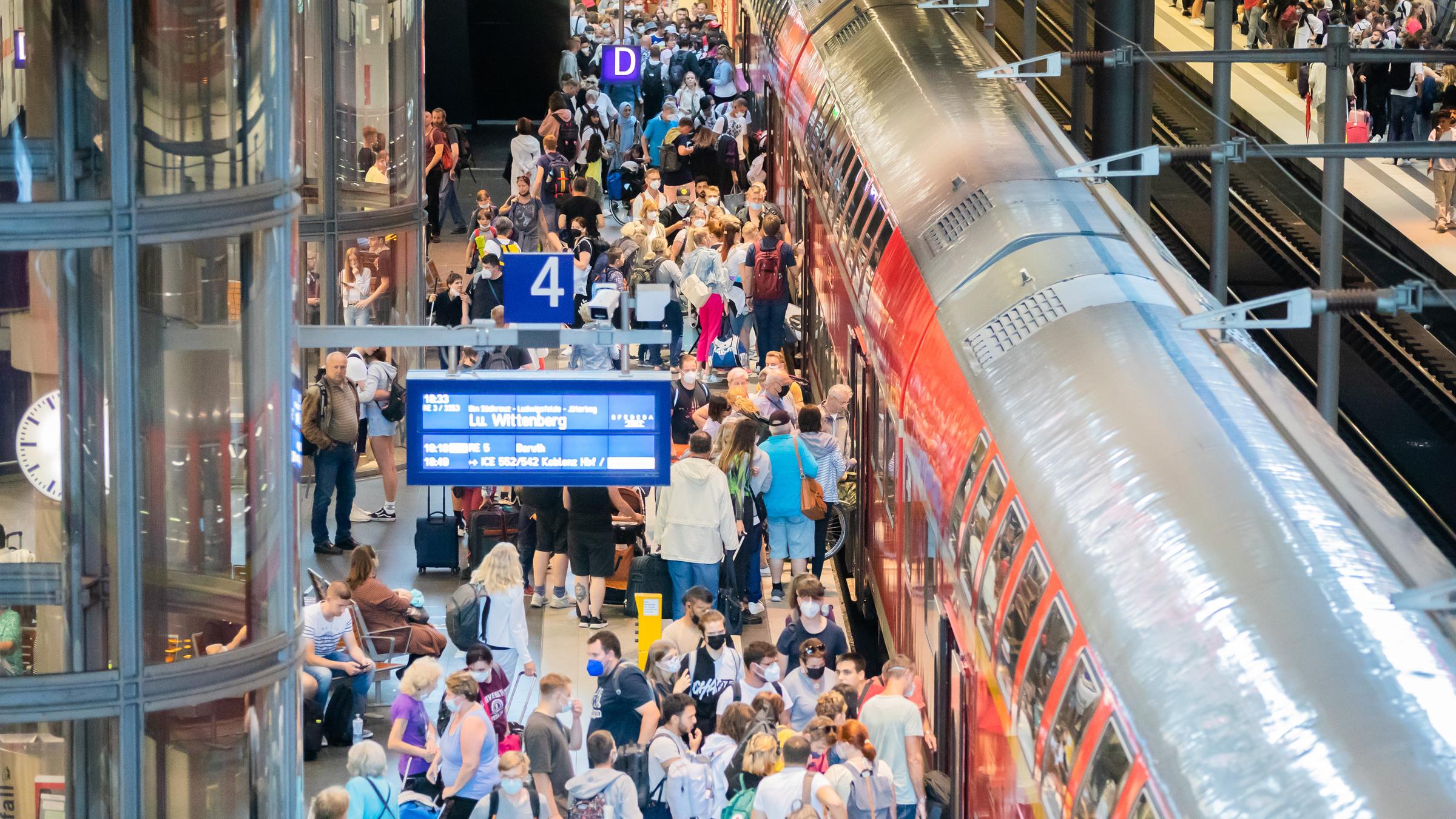 Überfüllter Bahnsteig von oben, eine Regionalbahn ist eingefahren. 
