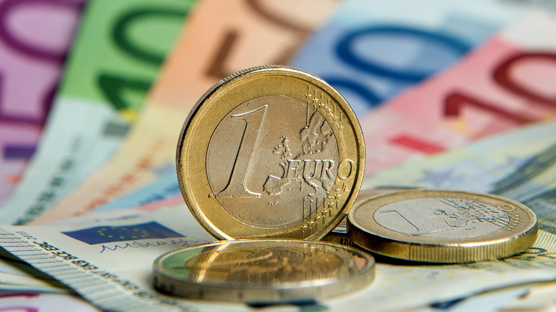 Zahlreiche Euro-Banknoten und Euromünzen