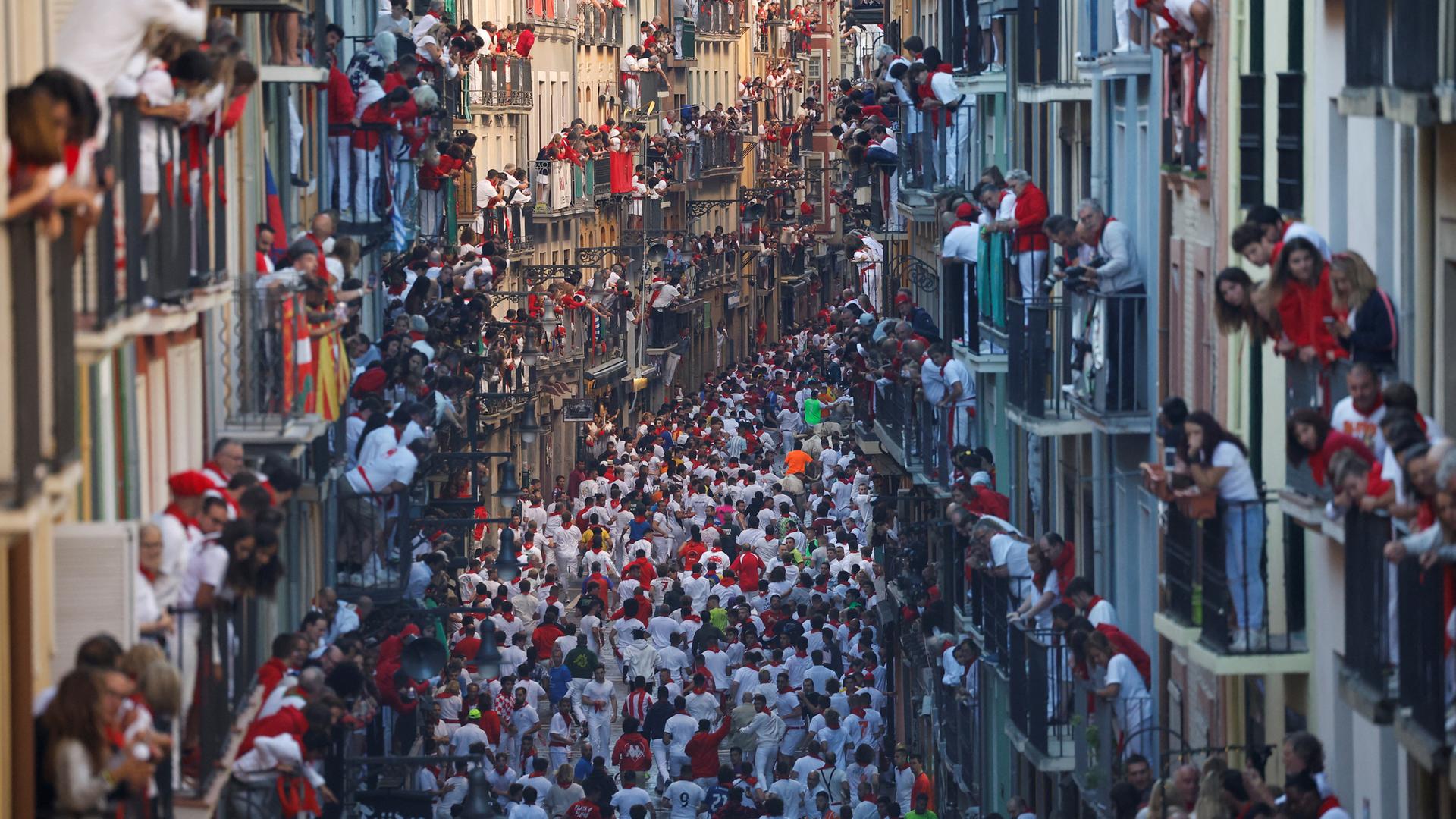 Menschen drängen sich bei Stierrennen auf der Straße. 