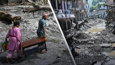 Menschen suchen nach einer Sturzflut in Nepal zwischen den Trümmern und im Schlamm nach ihren Sachen.