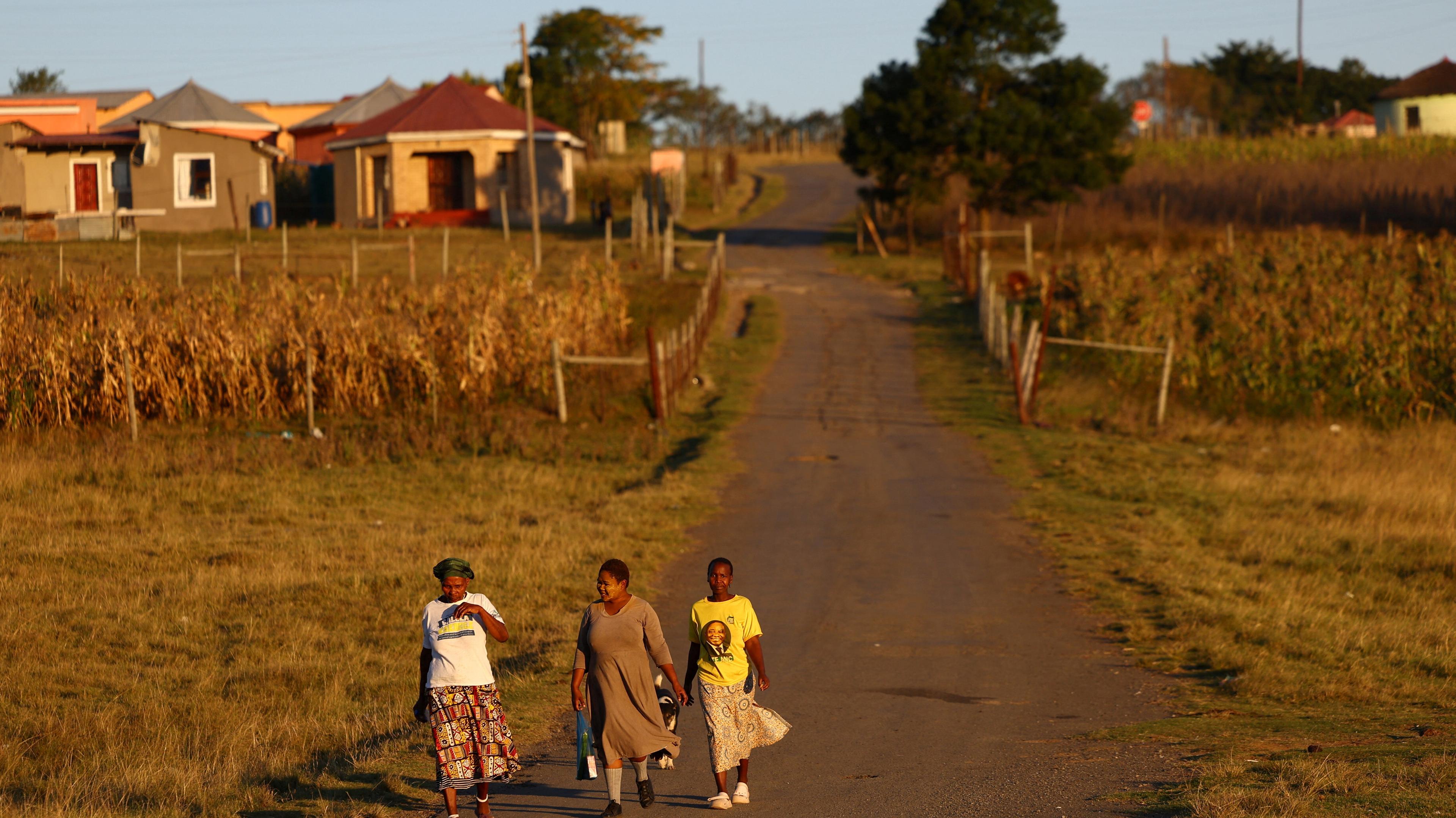 Feldweg in Südafrika, dei Frauen laufen weg entlang
