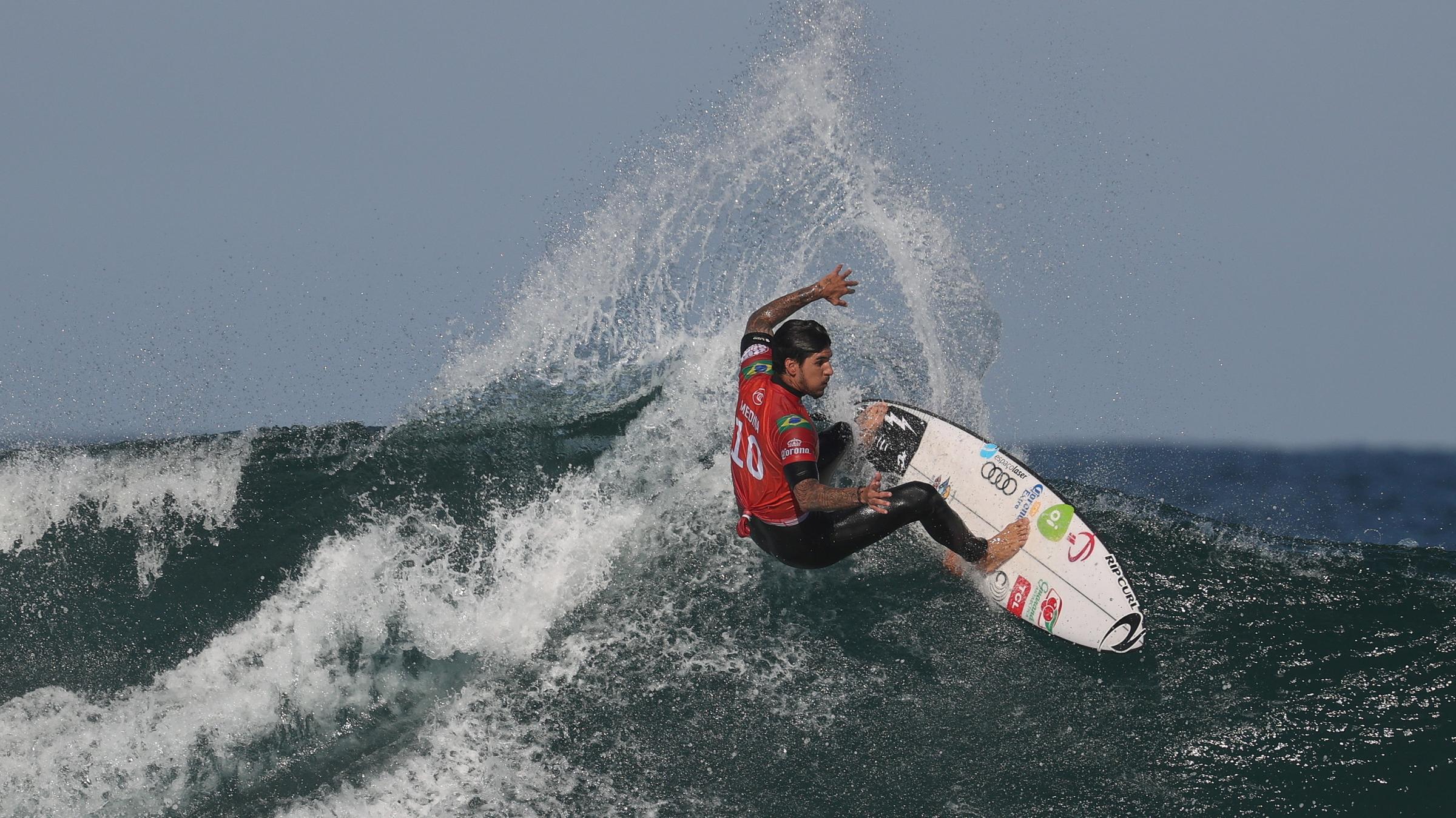 Ein Mann surft auf einer Welle im Meer.