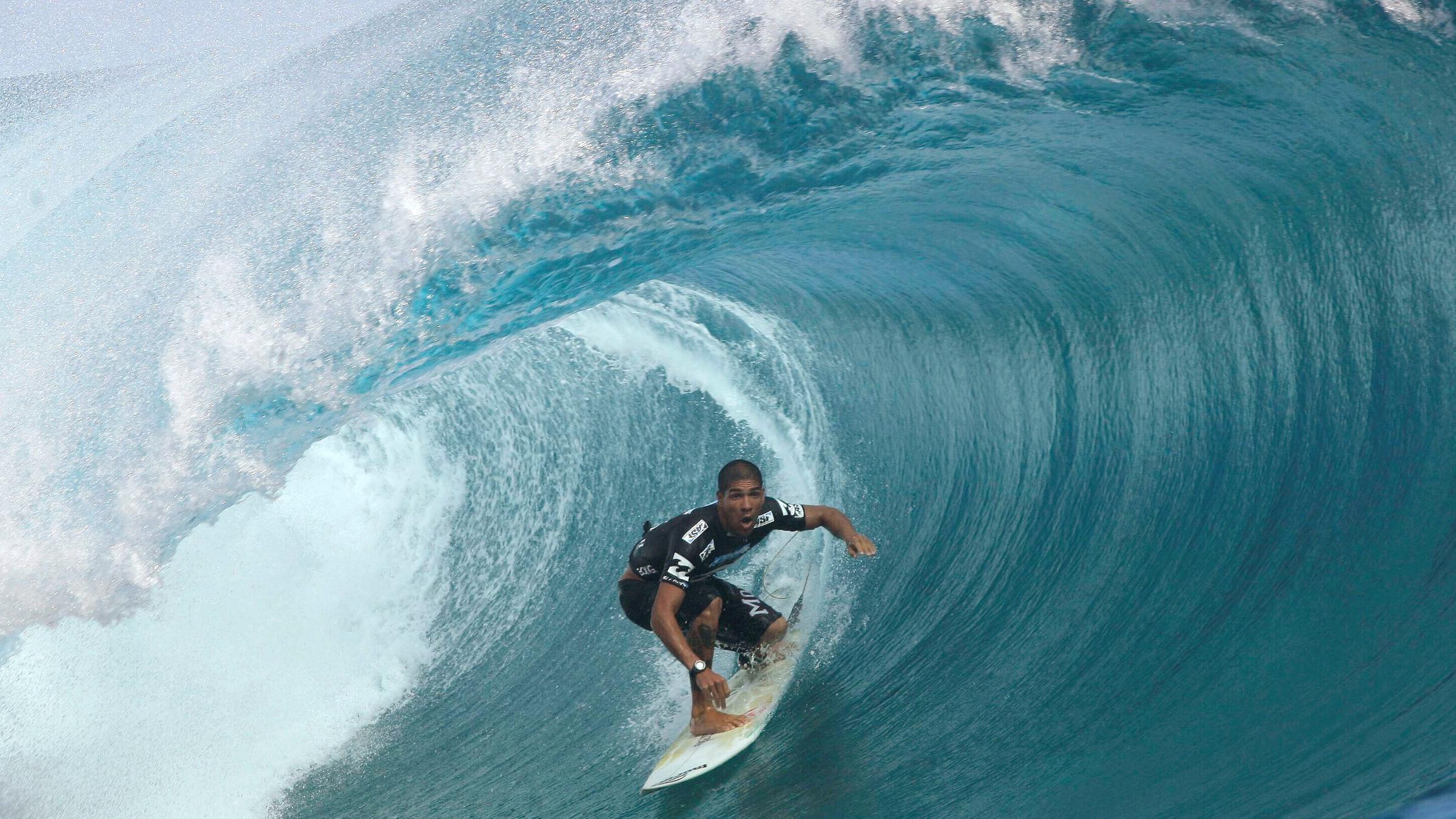 Ein Mann surft im blauen Wasser. 