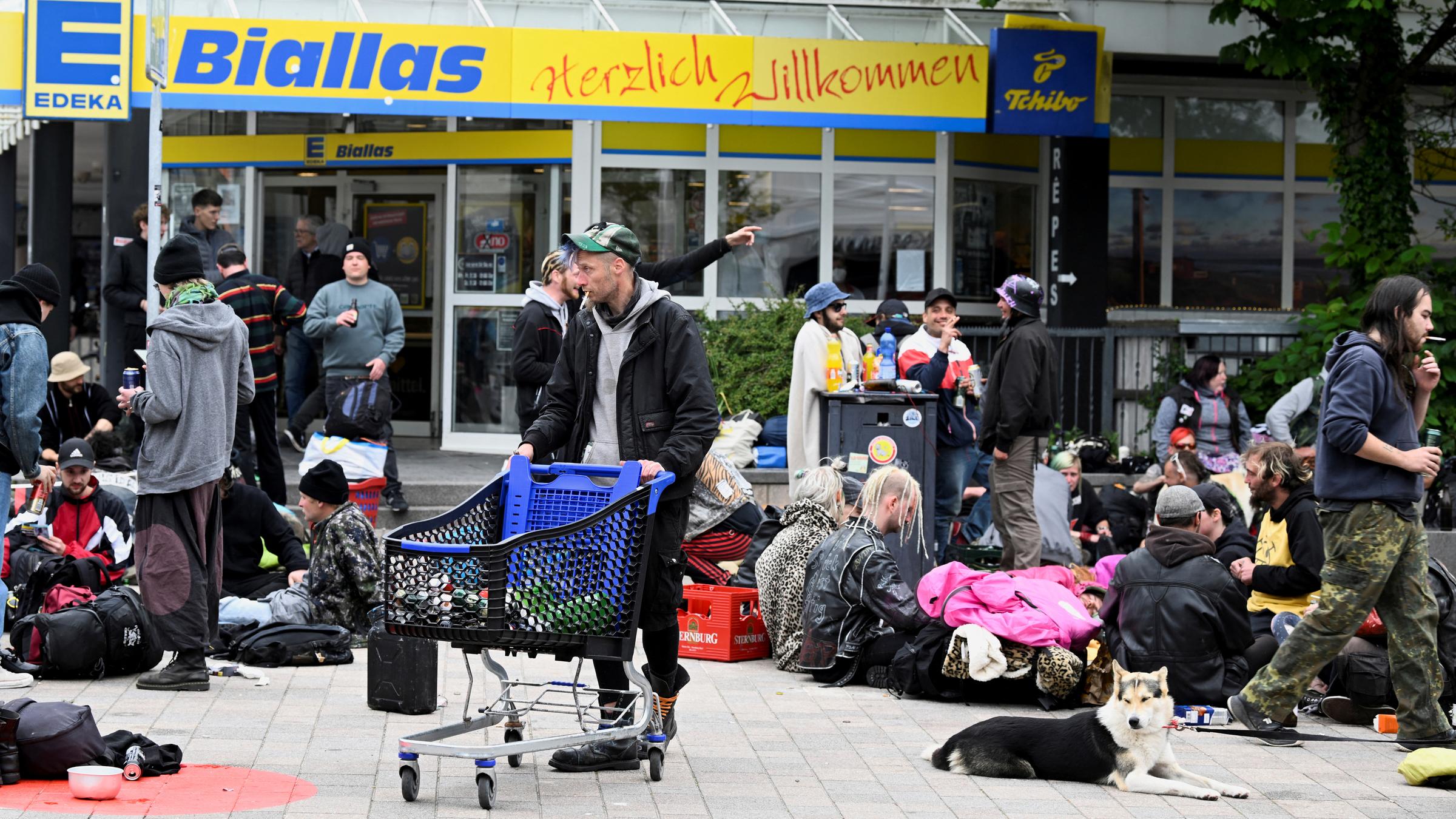Punks, die mit dem 9-Euro-Ticket nach Sylt gereist sind, trinken Bier vor einem Supermarkt.