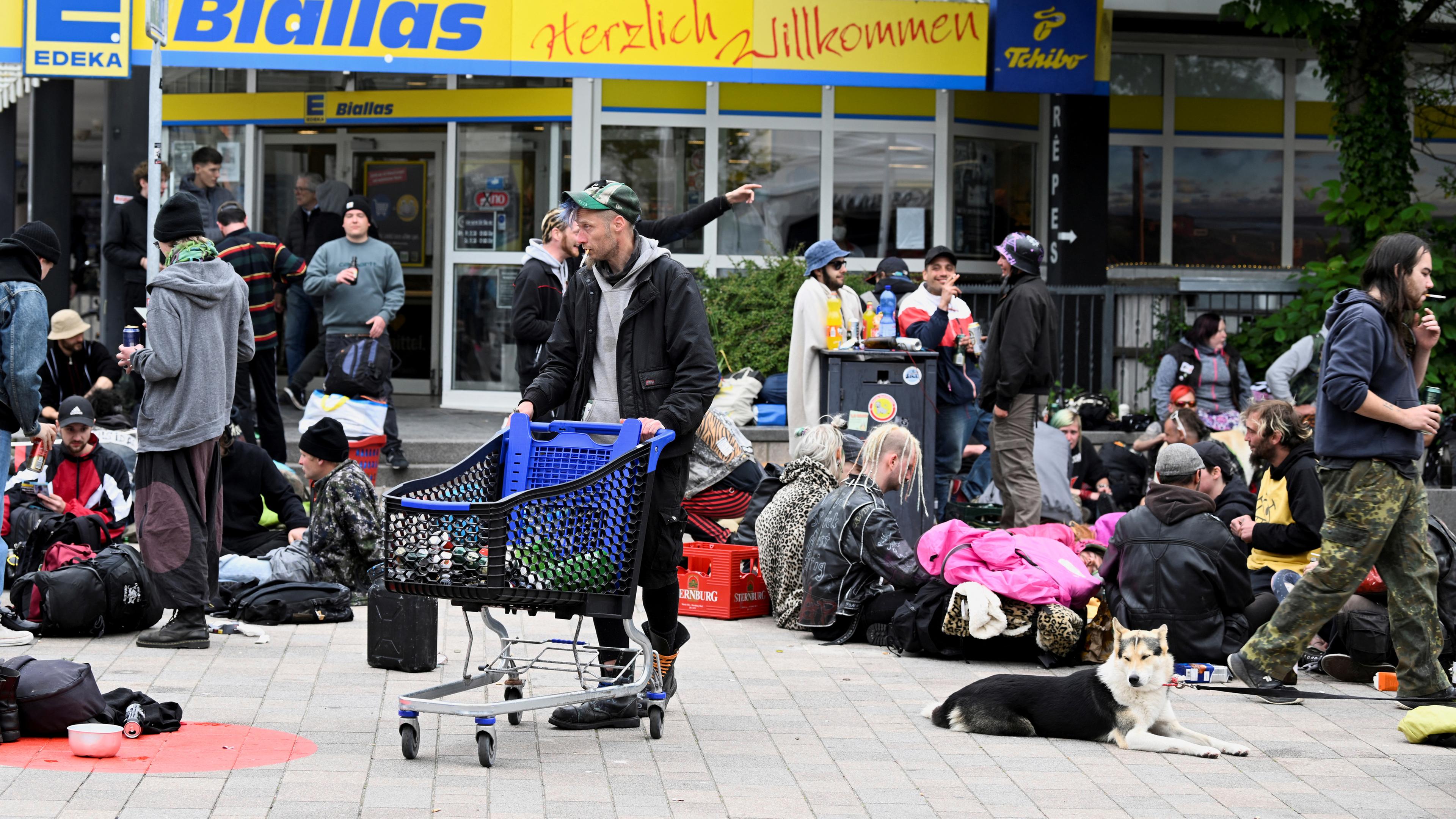 Punks, die mit dem 9-Euro-Ticket nach Sylt gereist sind, trinken Bier vor einem Supermarkt.