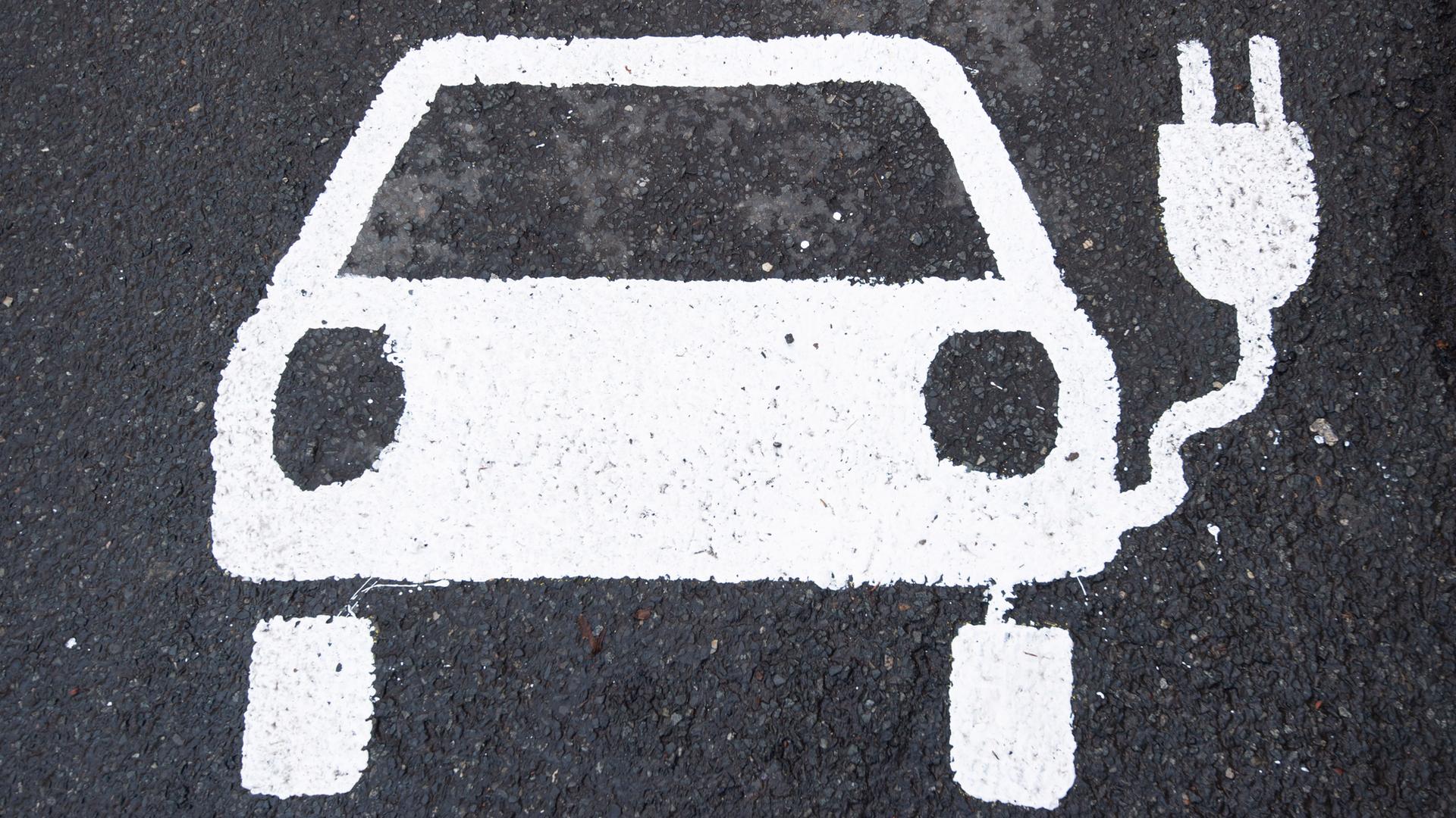 Symbol eines E-Autos auf eienr Straße.