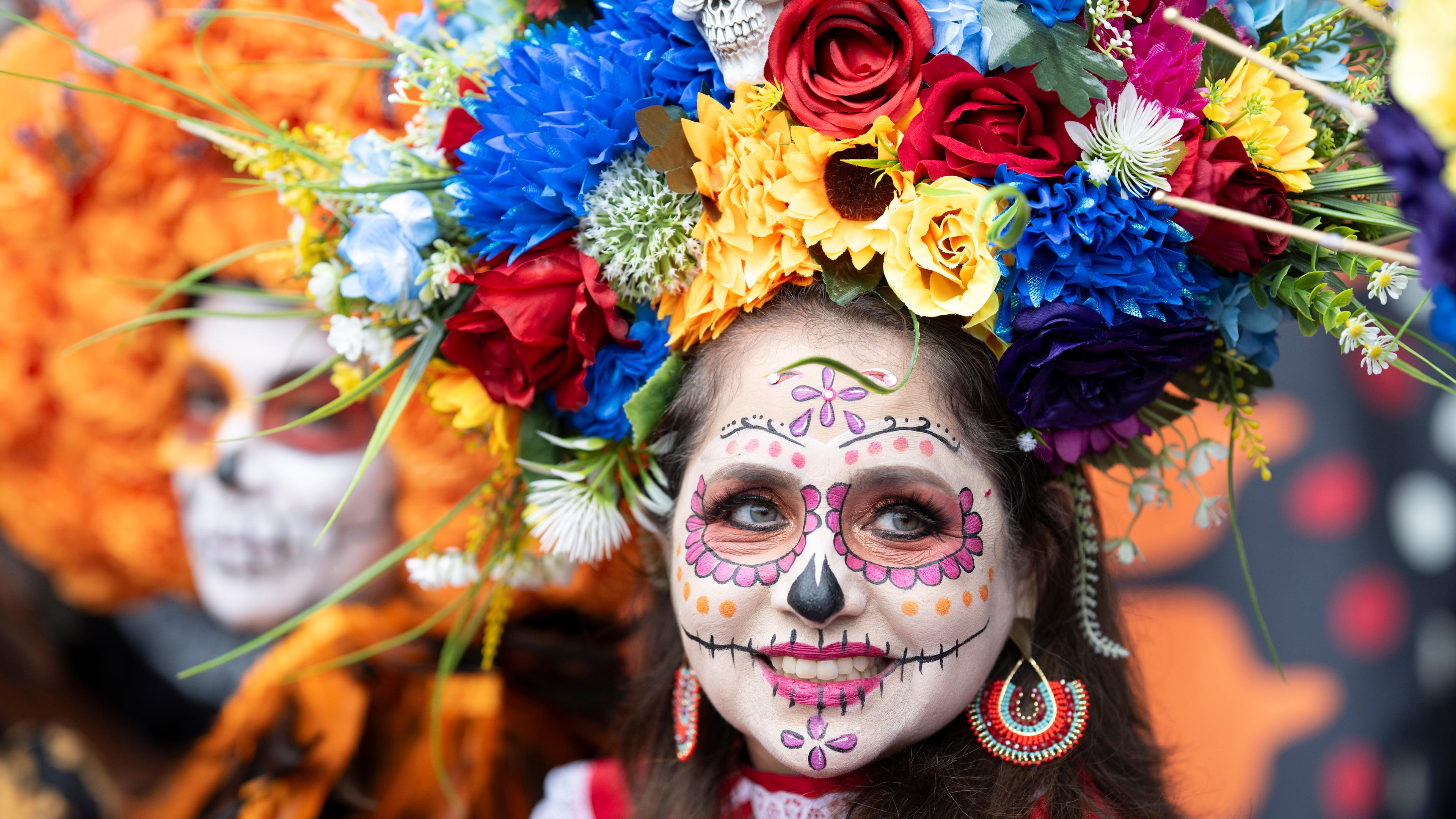 Aufwändig geschminkt sieht eine Teilnehmerin der Parade zum Tag der Toten in Frankfurt am Main in die Kamera.