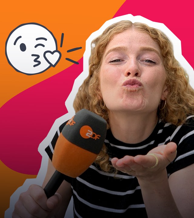 Vor einem rot-orangenen Hintergrund ist Reporterin Lara mit Mikrofon zu sehen. Sie macht einen Kussmund in die Kamera. Neben ihr befindet sich ein Kuss-Emoji.