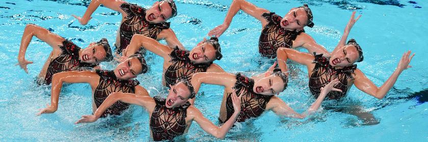 Schwimmerinnen führen ein Kunststück auf. 