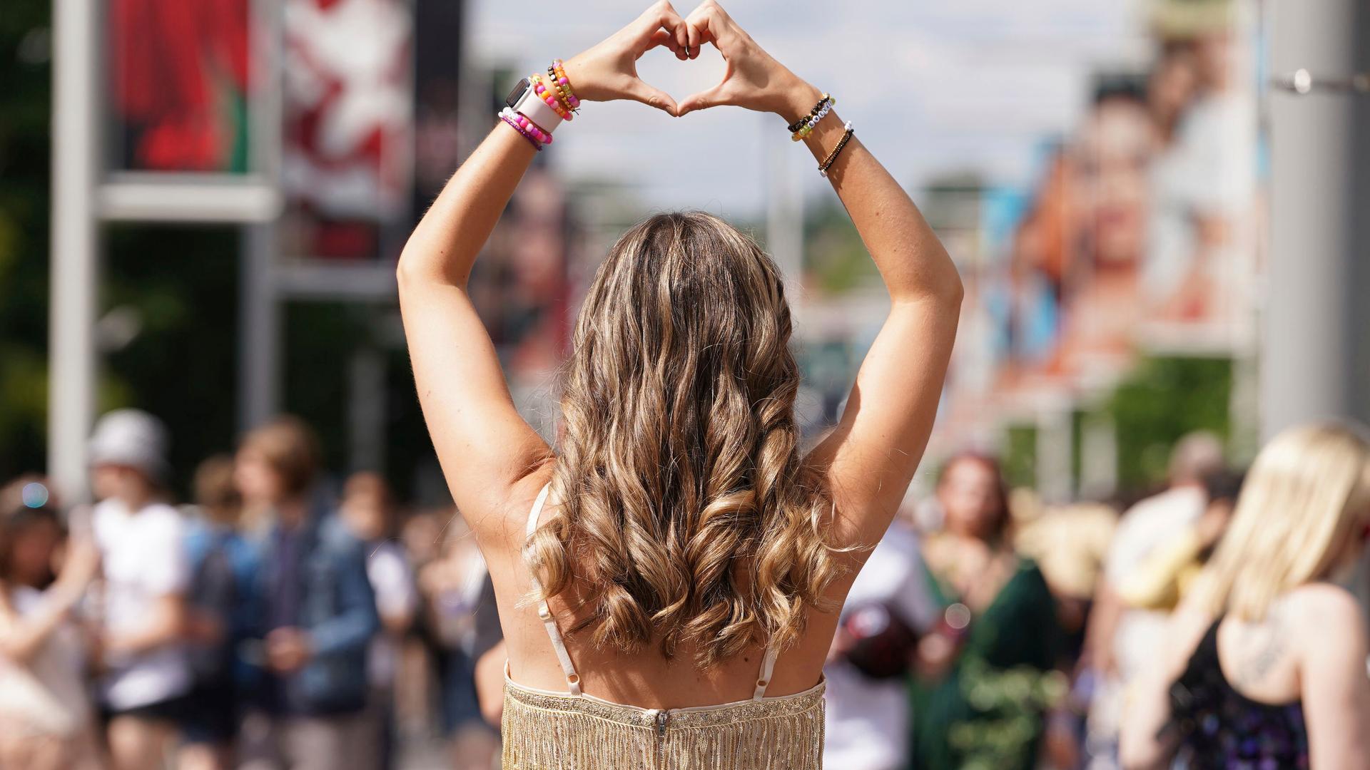 Taylor Swift Fan formt ein Herz mit den Händen.