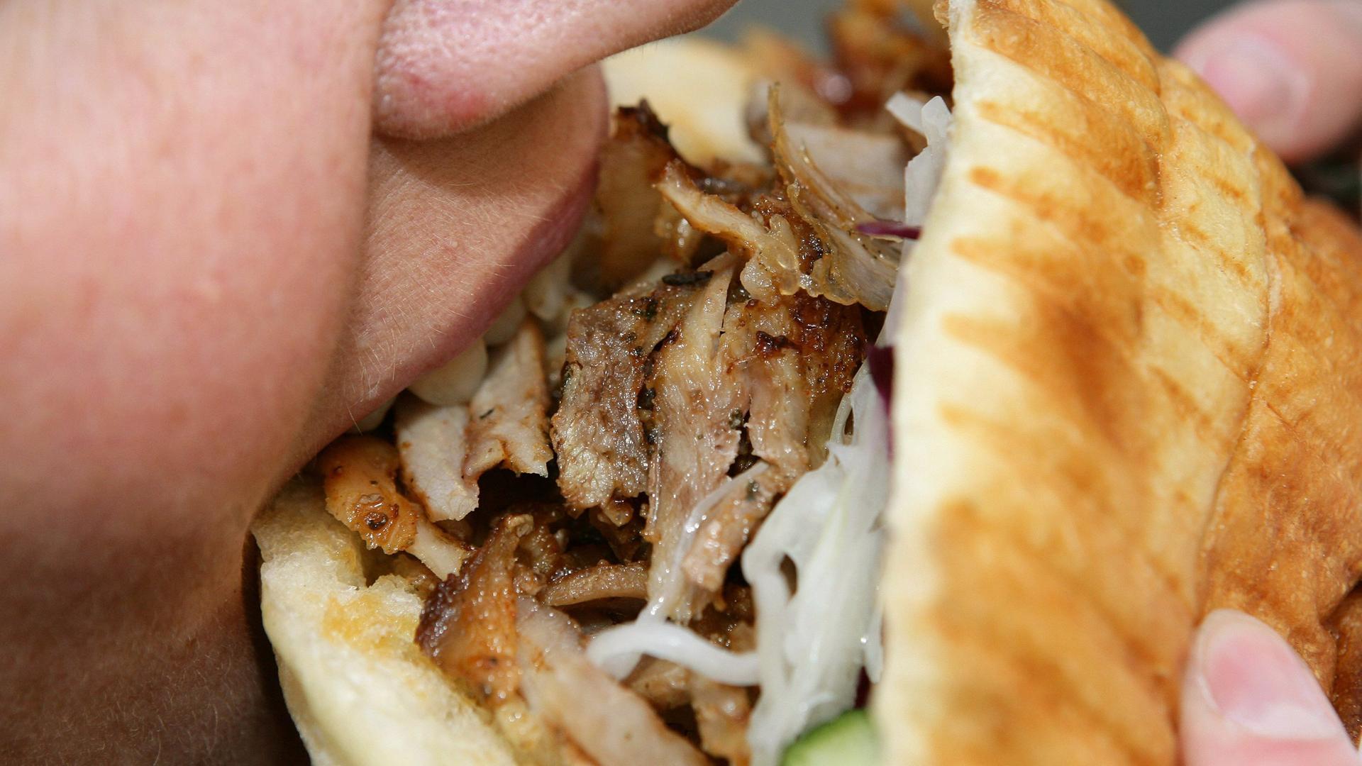 Kind beißt in einen Döner .