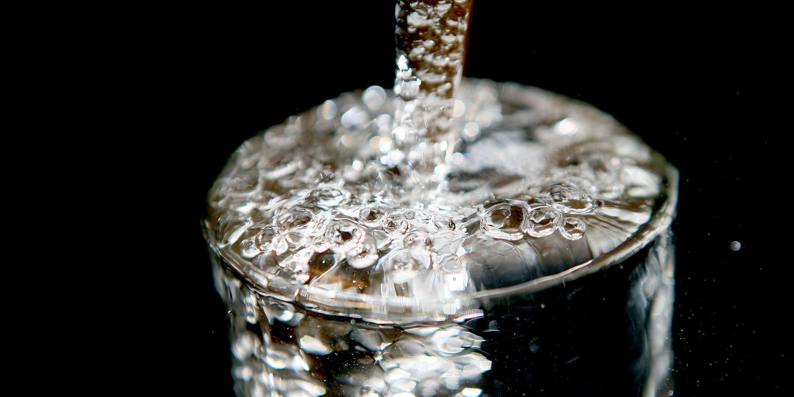 Ein Glas läuft voll Trinkwasser. Archivbild