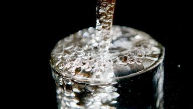 Ein Glas läuft voll Trinkwasser. Archivbild