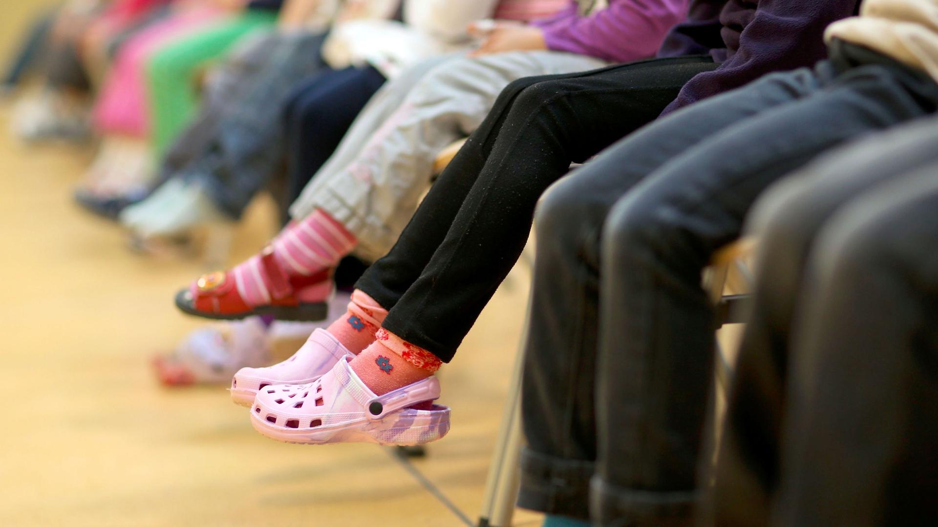 Kinder lassen ihre Beine baumeln. Symbolbild