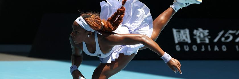 Tennisspielerin Coco Gauff mit einem Bein auf dem Boden unddem anderen in der Luft. Sie ist nach vorne gebeugt im Match.