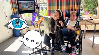 Teresa mit Kind, das mit Sprachcomputer spricht