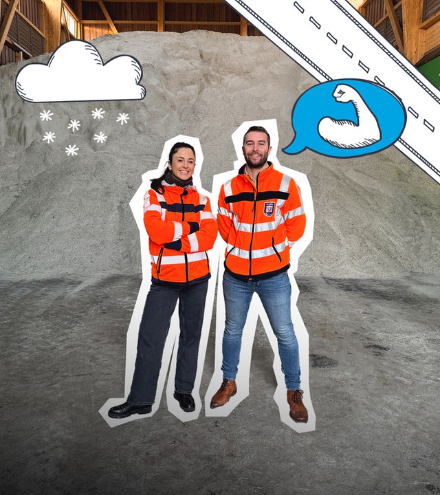 Teresa und ein Mann stehen vor einem riesigen Haufen Salz für die Straßenmeisterei.