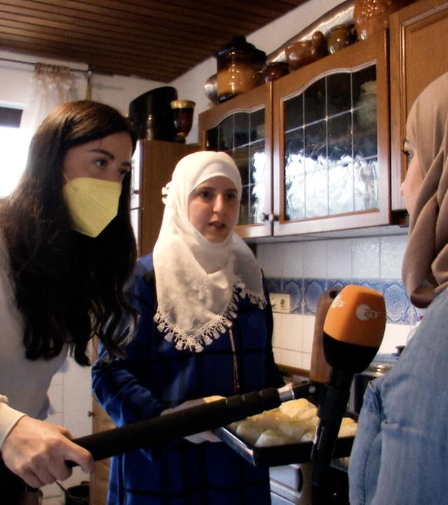 Reporterin Teresa bei einer syrischen Familie, die für Flutopfer kocht.