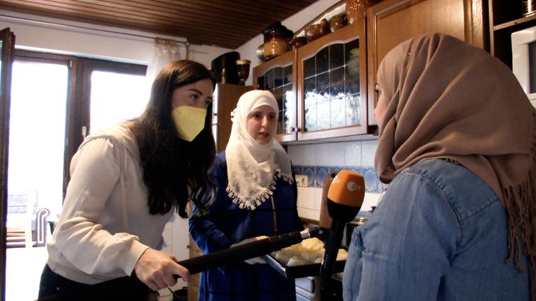 Reporterin Teresa bei einer syrischen Familie, die für Flutopfer kocht.