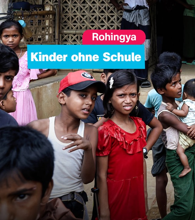 Mehrere Kinder in einem Geflüchtetenlager schauen in die Kamera. 