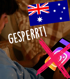 Ein Junge zeigt sein Handy in die Kamera, darauf zu sehen ist der Hinweis auf das Social-Media-Verbot in Australien.