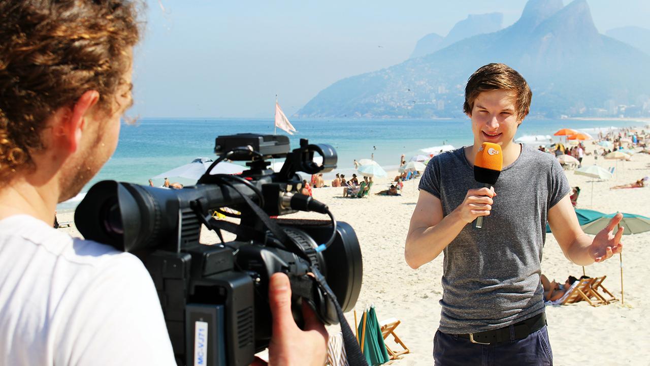 Tim steht auf dem Copacabana-Strand in Rio de Janeiro.