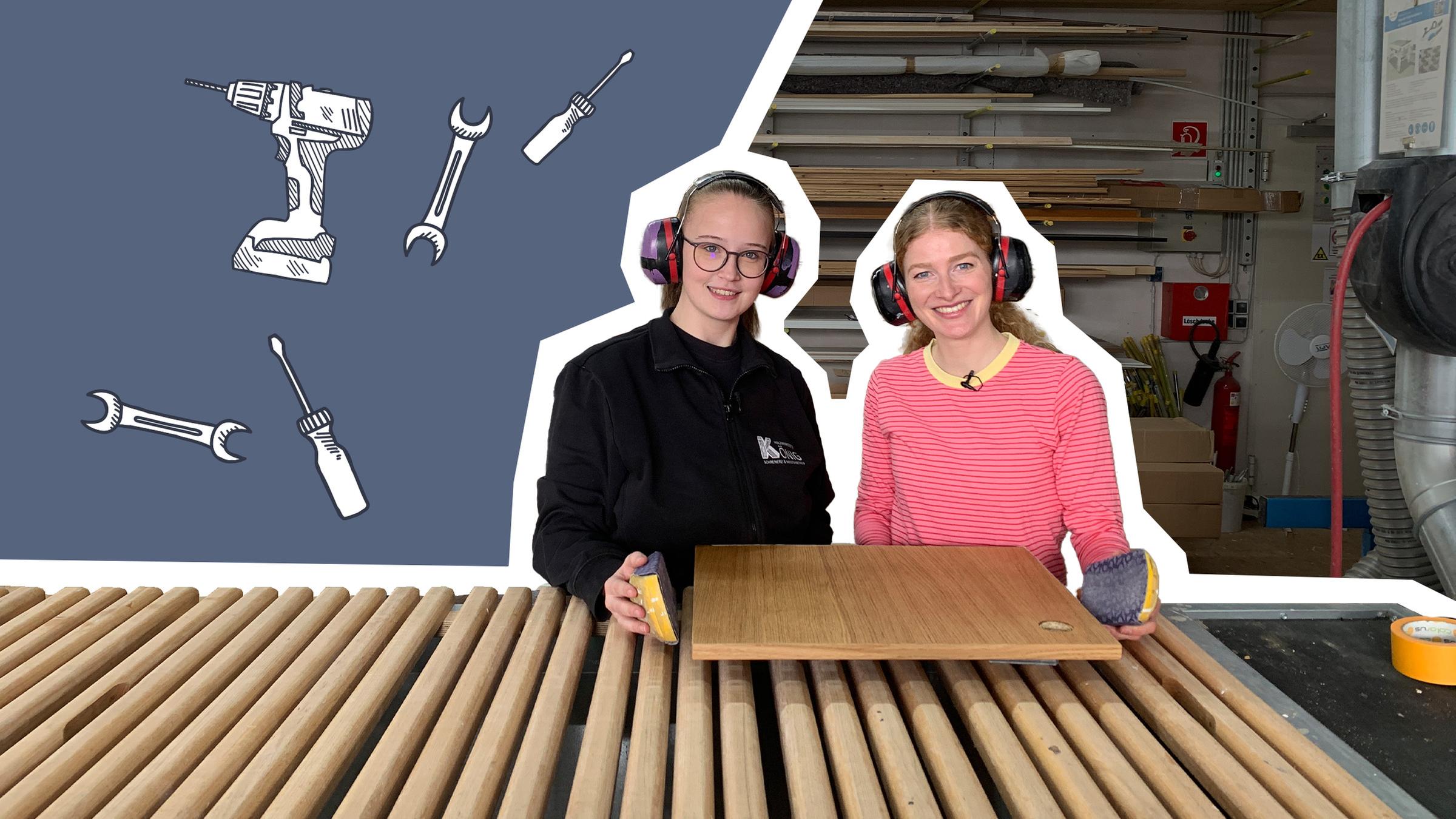 Lara und Lisa stehen vor einem Brett und haben Gehörschutz auf