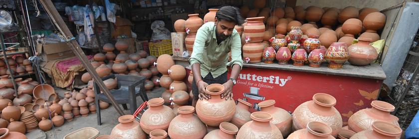 Mann arrangiert Tonkrüge zum Verkaufen in Indien