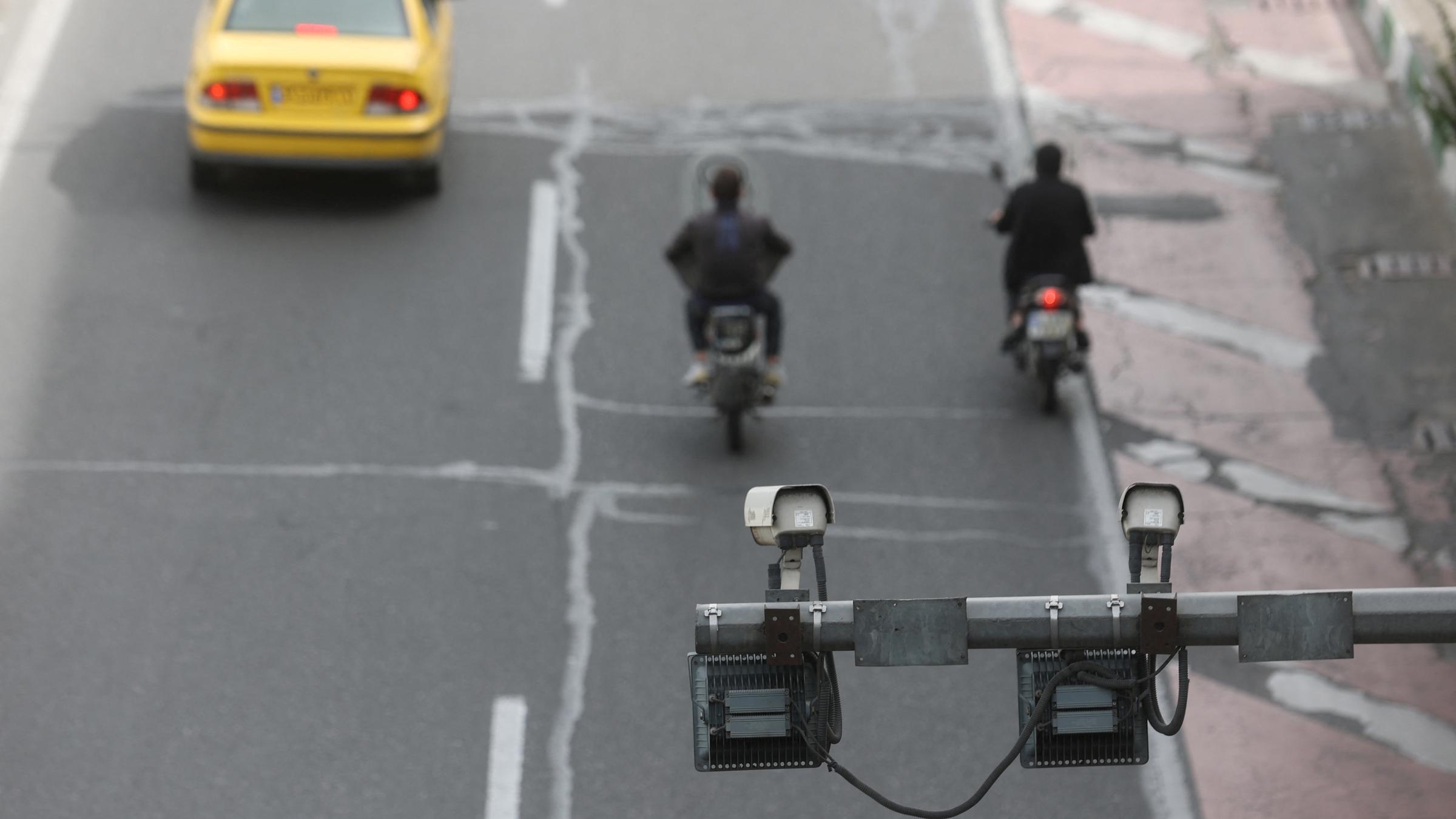 Überwachungskamera über Straße in Theran, darunter fahren Autos entlang