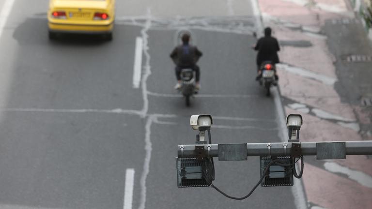 Überwachungskamera über Straße in Theran, darunter fahren Autos entlang