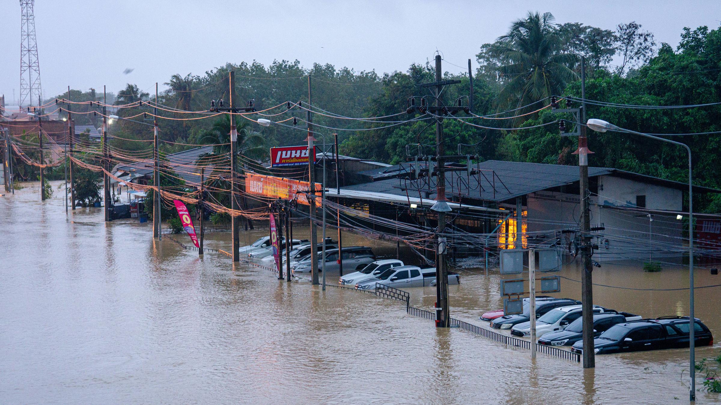 Die Straße und die Autos stehen in einem Vorort von Hat Yai unter Wasser.