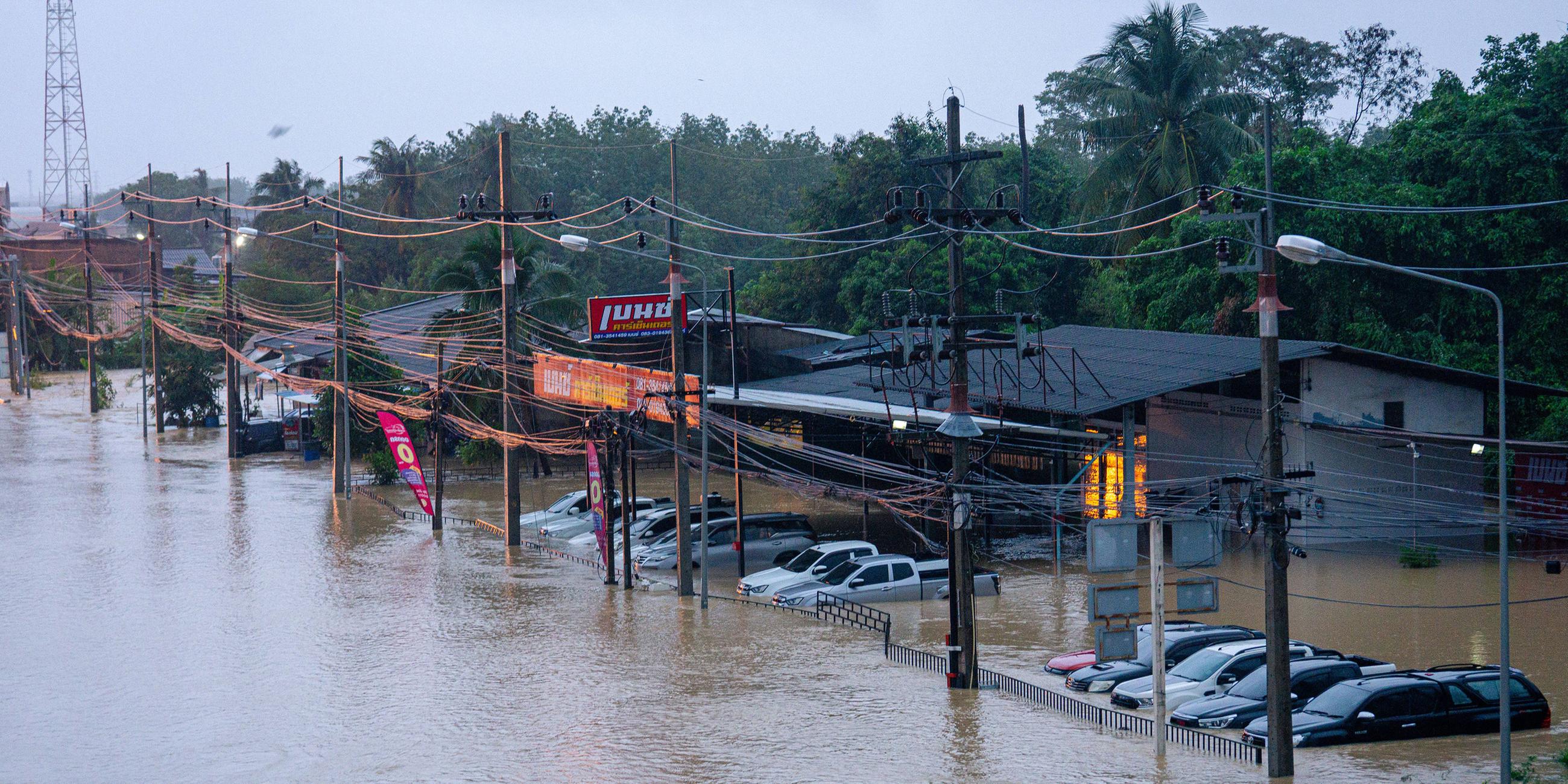 Die Straße und die Autos stehen in einem Vorort von Hat Yai unter Wasser.