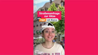 Person mit weißer Kappe und hellem T-Shirt vor einem unscharfen Stadtplatz-Hintergrund. Darüber Texteinblendung „Straßenumfrage zur Hitze mit Bianca“.