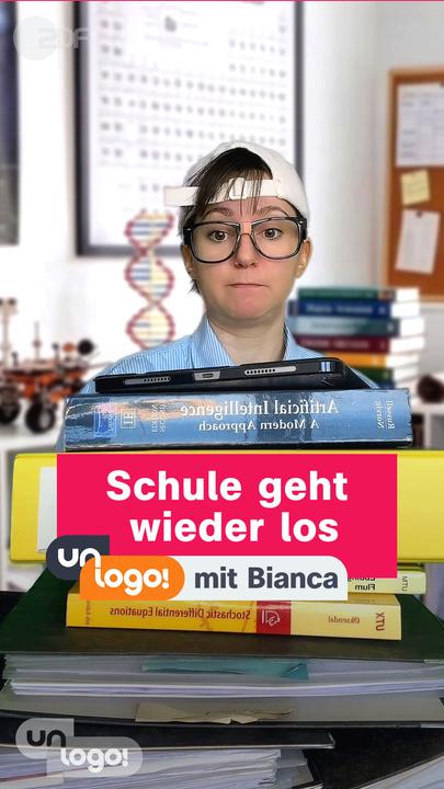 Ein Kind sitzt vor einem Turm aus Büchern und Ordnern