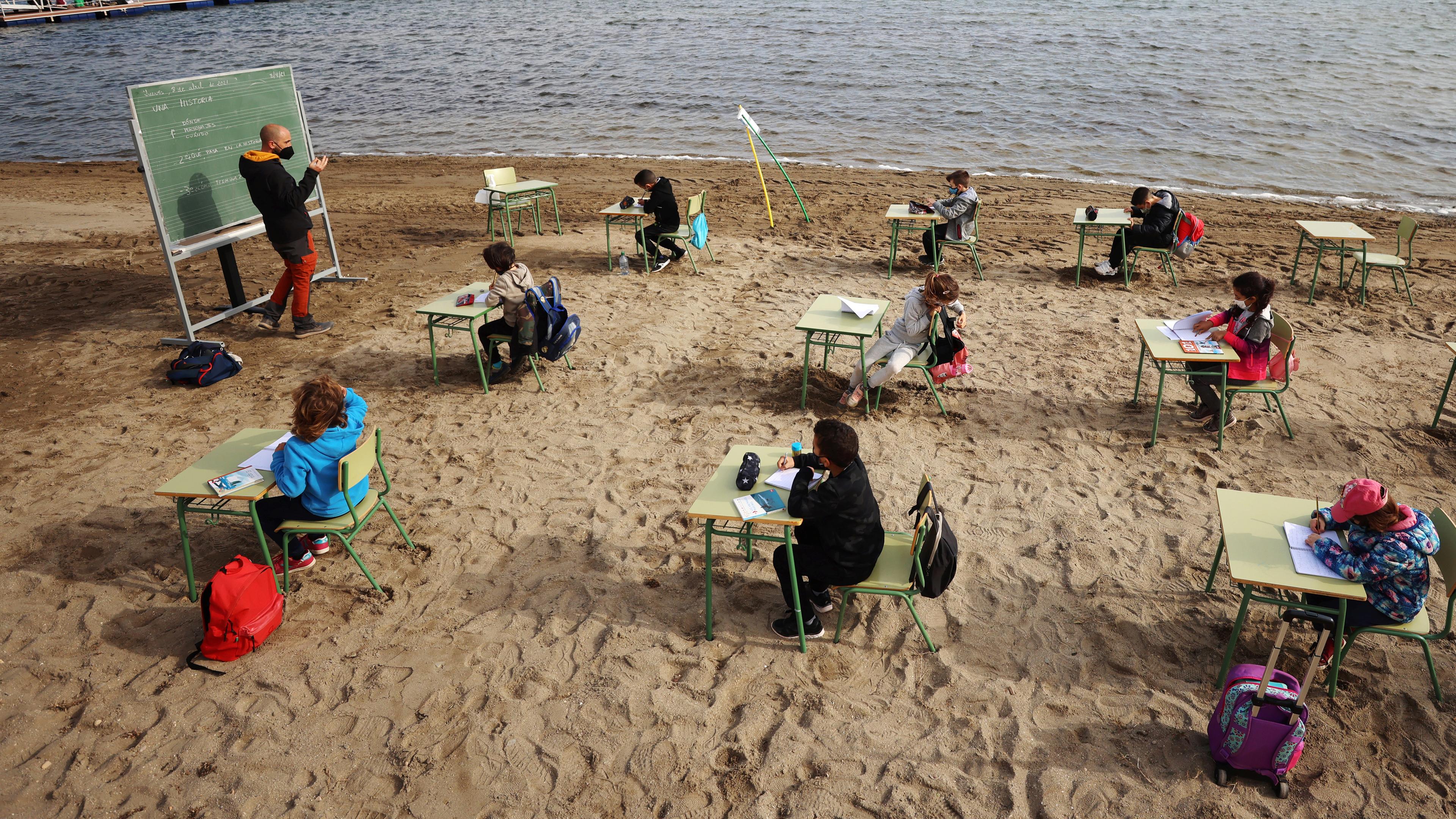Schülerinnen und Schüler lernen am Strand. 