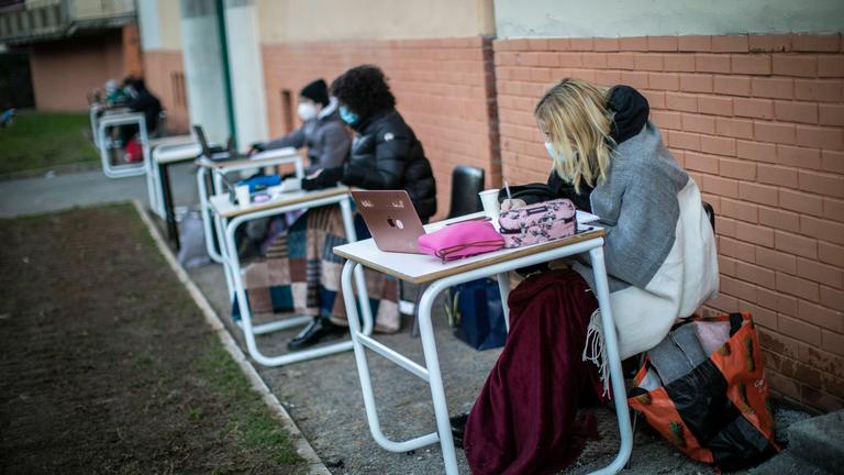 Schülerinnen und Schüler an Tischen und Stühlen überall in der Stadt Bergamo. 