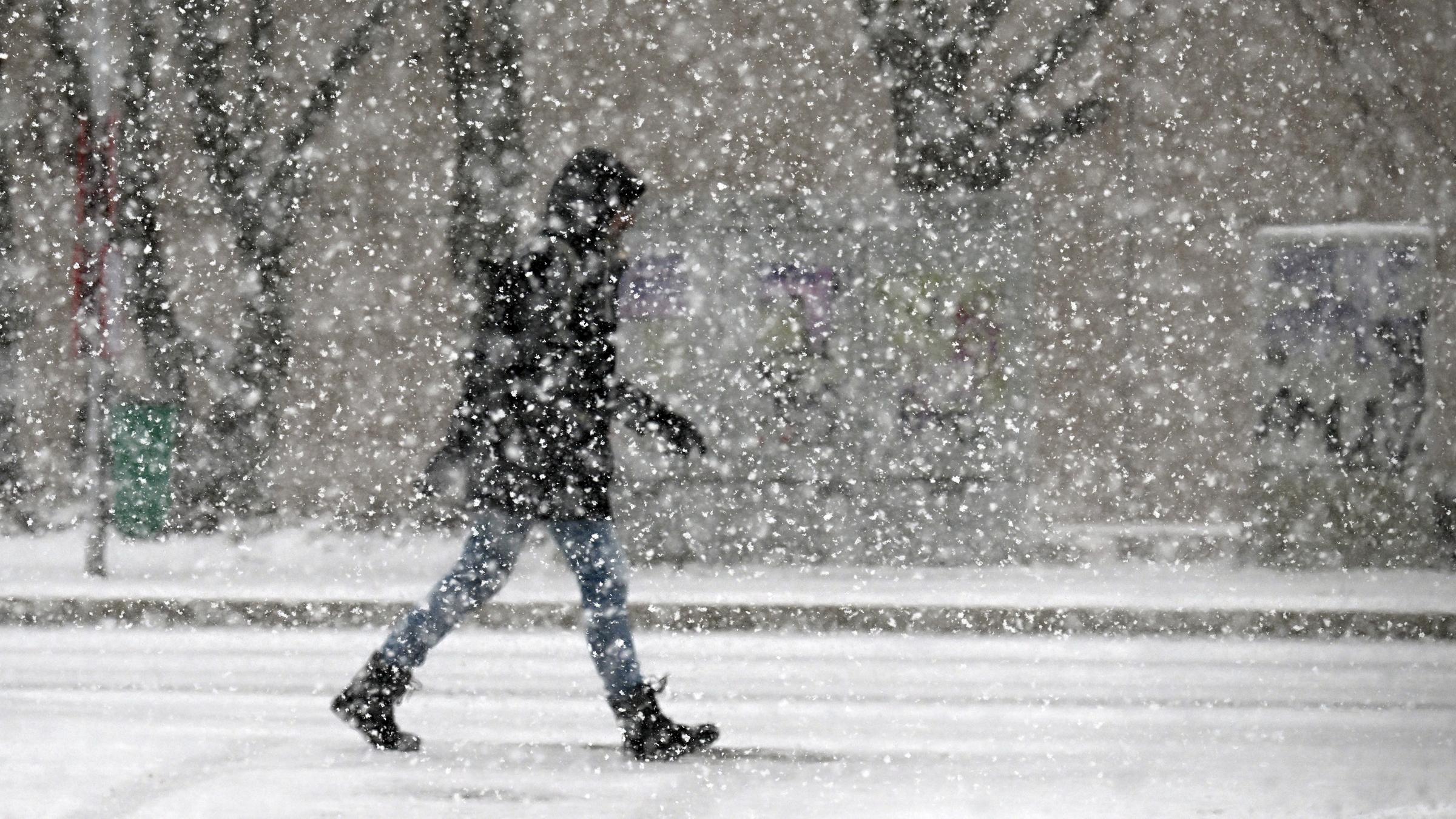 Ein Fußgänger geht durch den Schnee. In Nordrhein-Westfalen kündigt sich neuer Schnee an.