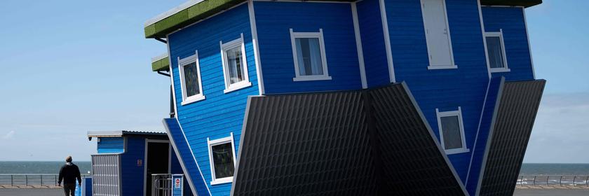 Ein Mann läuft am "Upside Down House" in Blackpool in England vorbei.