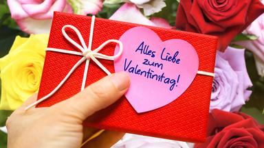 Ein rotes Geschenk mit einem Herzaufdruck und dem Titel "Alles Liebe zum Valentinstag"