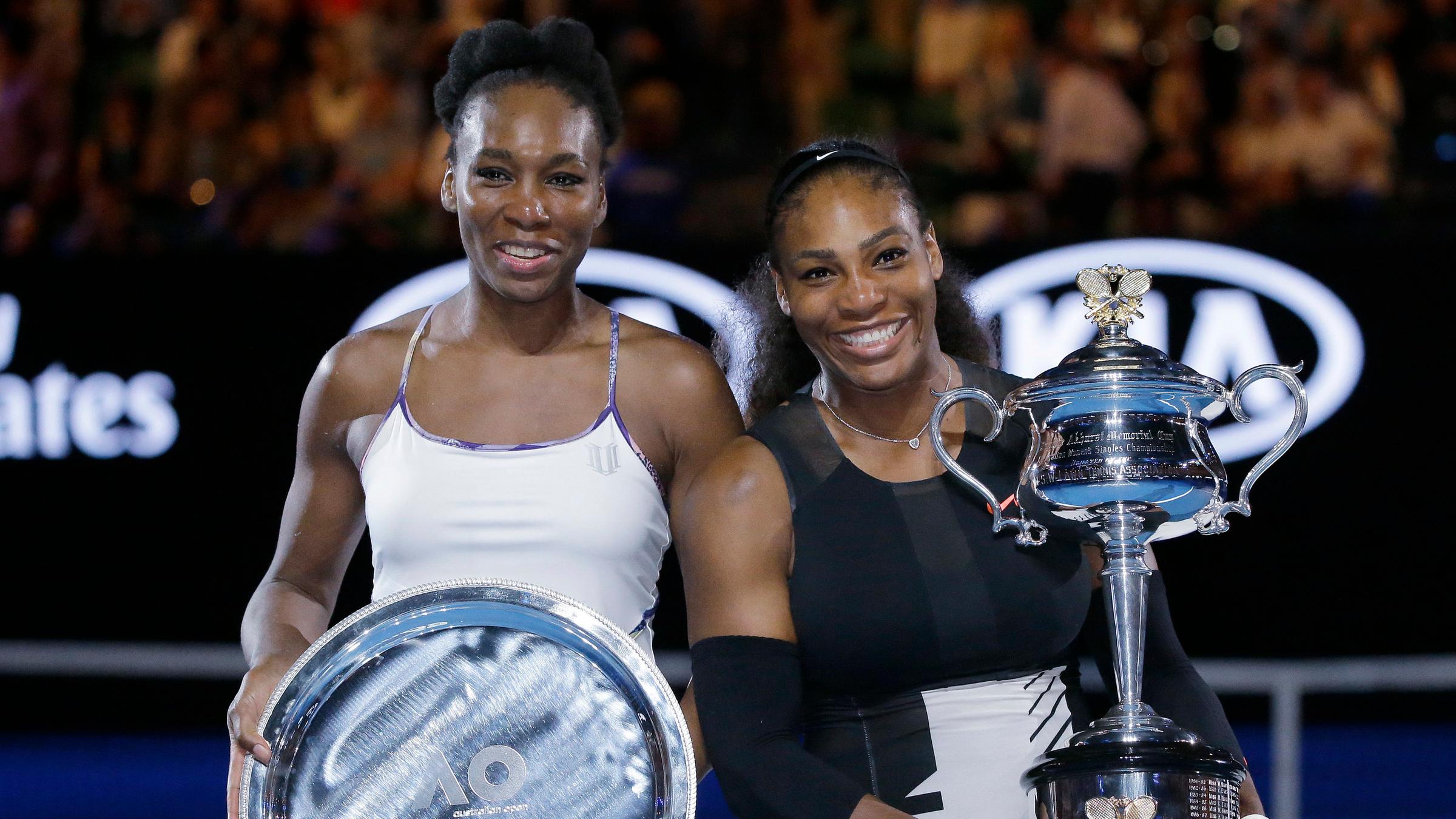 Venus Williams und Serena Williams halten ihr Trophäen nach dem Finale der Australian Open 2017 in den Händen.