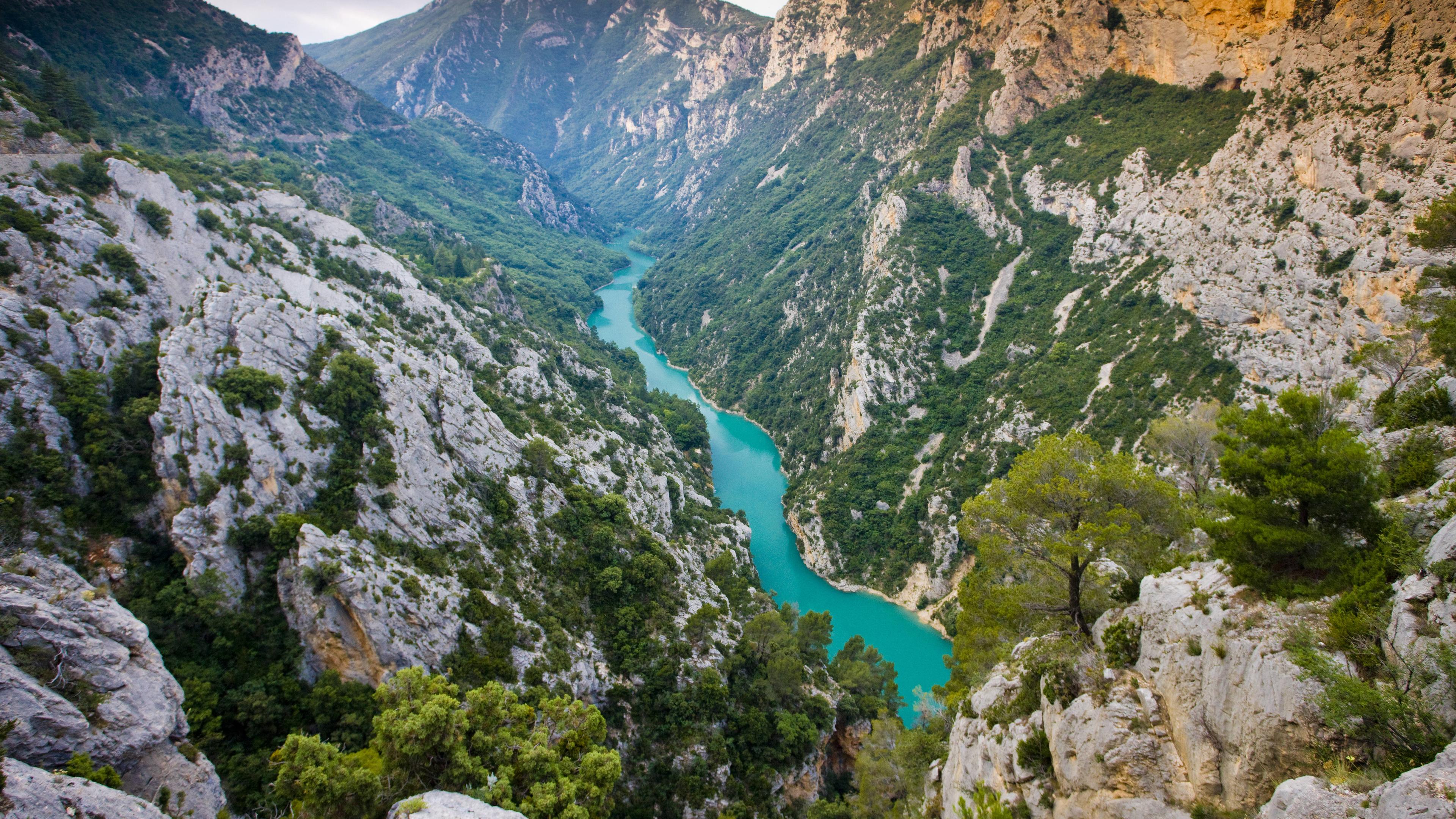 Man sieht Berge und einen türkisblauen Fluss im Tal