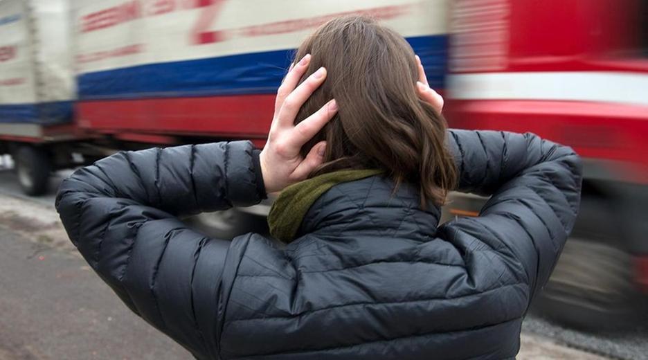 Frau hält sich die Ohren zu