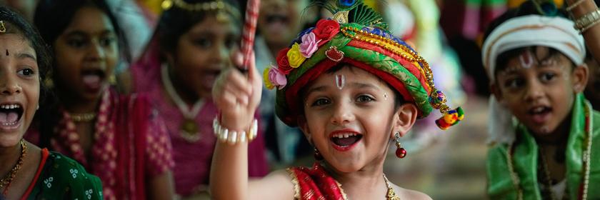Kinder in traditioneller Kleidung lachen.