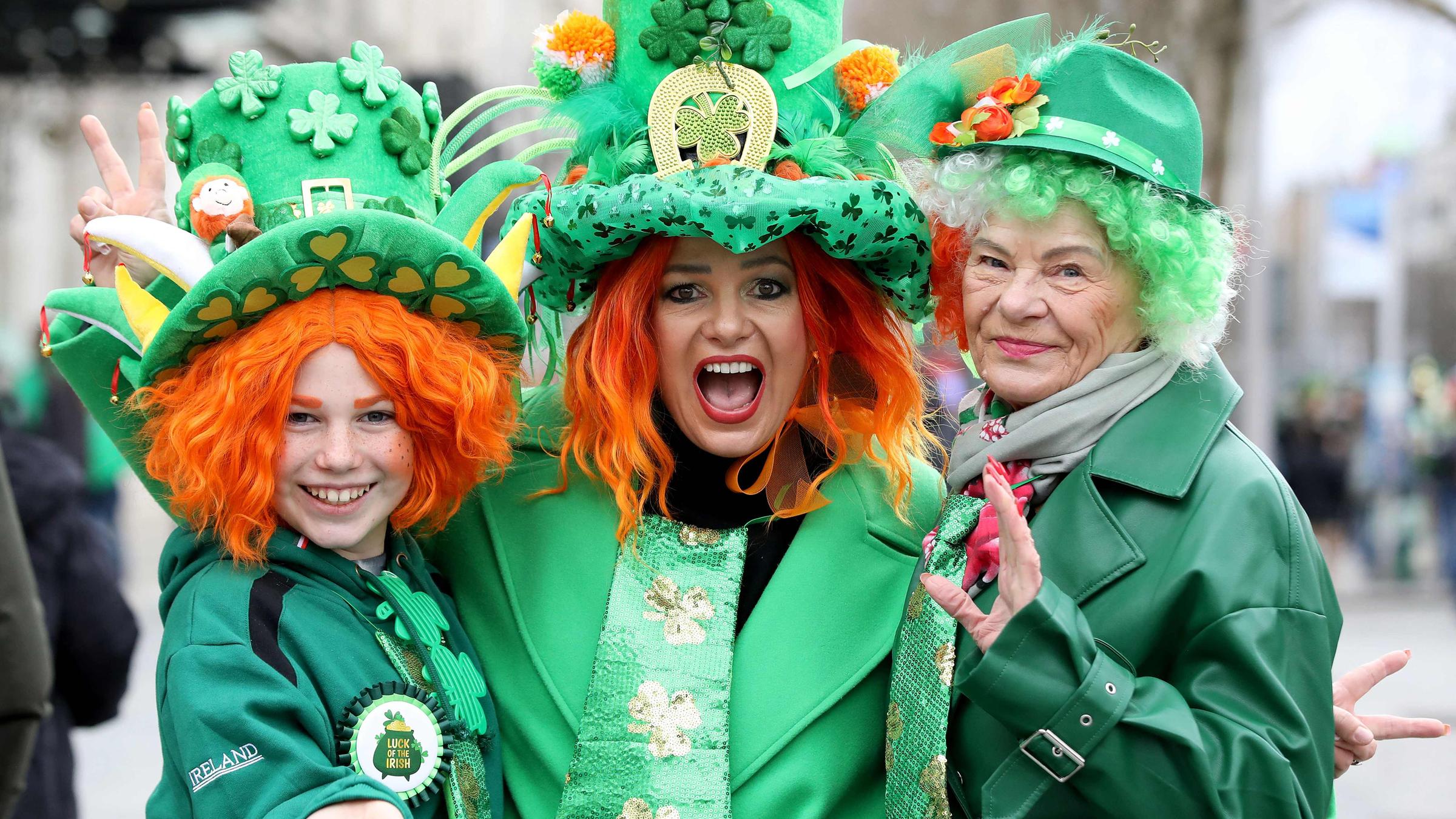 Drei Frauen in grünen Klamotten und roten Perücken
