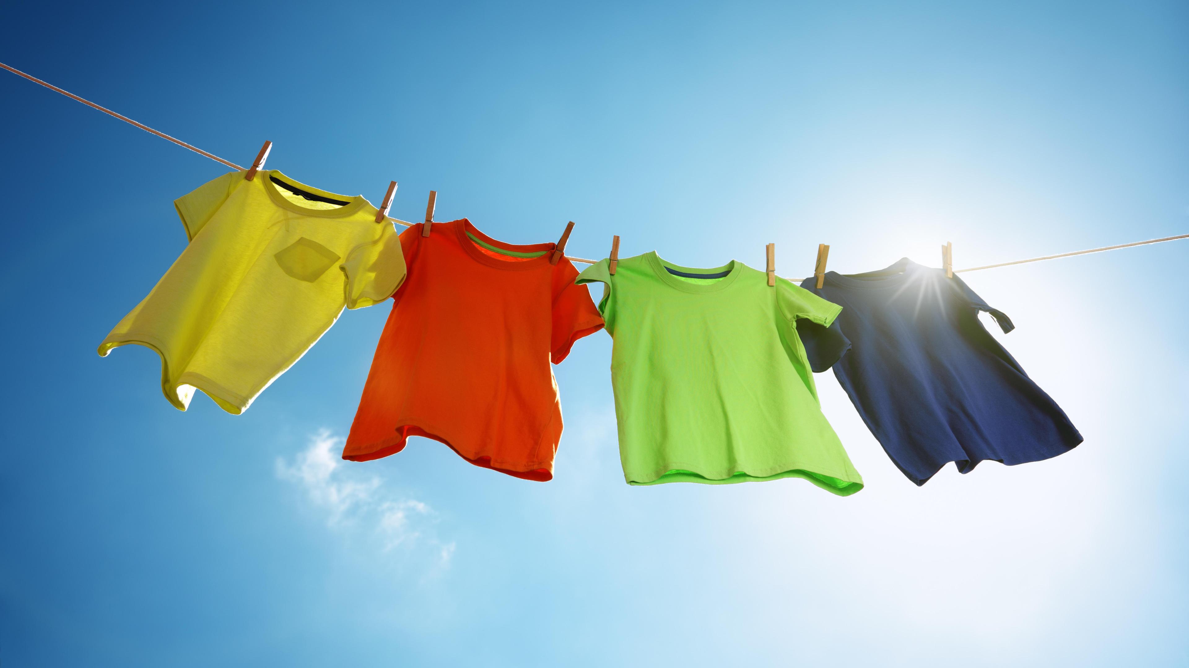 Bunte T-Shirts hängen an einer Leine