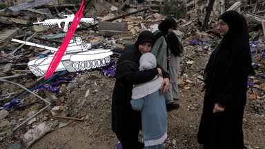 Eine Frau umarmt ihre weinende Tochter, während vertriebene Bewohner nach Inkrafttreten einer Waffenruhe zwischen Israel und der Hisbollah zurückkehren, dazu Grafik mit durchgestrichenen Waffen.