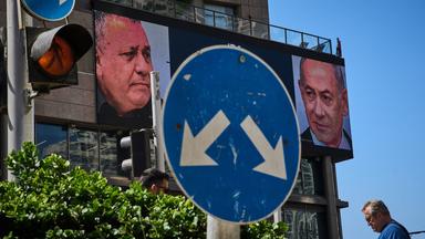 Ein Mann geht an einer Werbung vorbei, auf der der israelische Ministerpräsident Benjamin Netanjahu (r) und sein Hauptkonkurrent, der Oppositionskandidat Gadi Eisenkot, im Vorfeld der Parlamentswahlen in Israel zu sehen sind. Am 27. Oktober soll ein neues israelisches Parlament gewählt werden. 