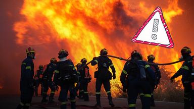 Feuerwehrmänner mit Schlauch vor Brand